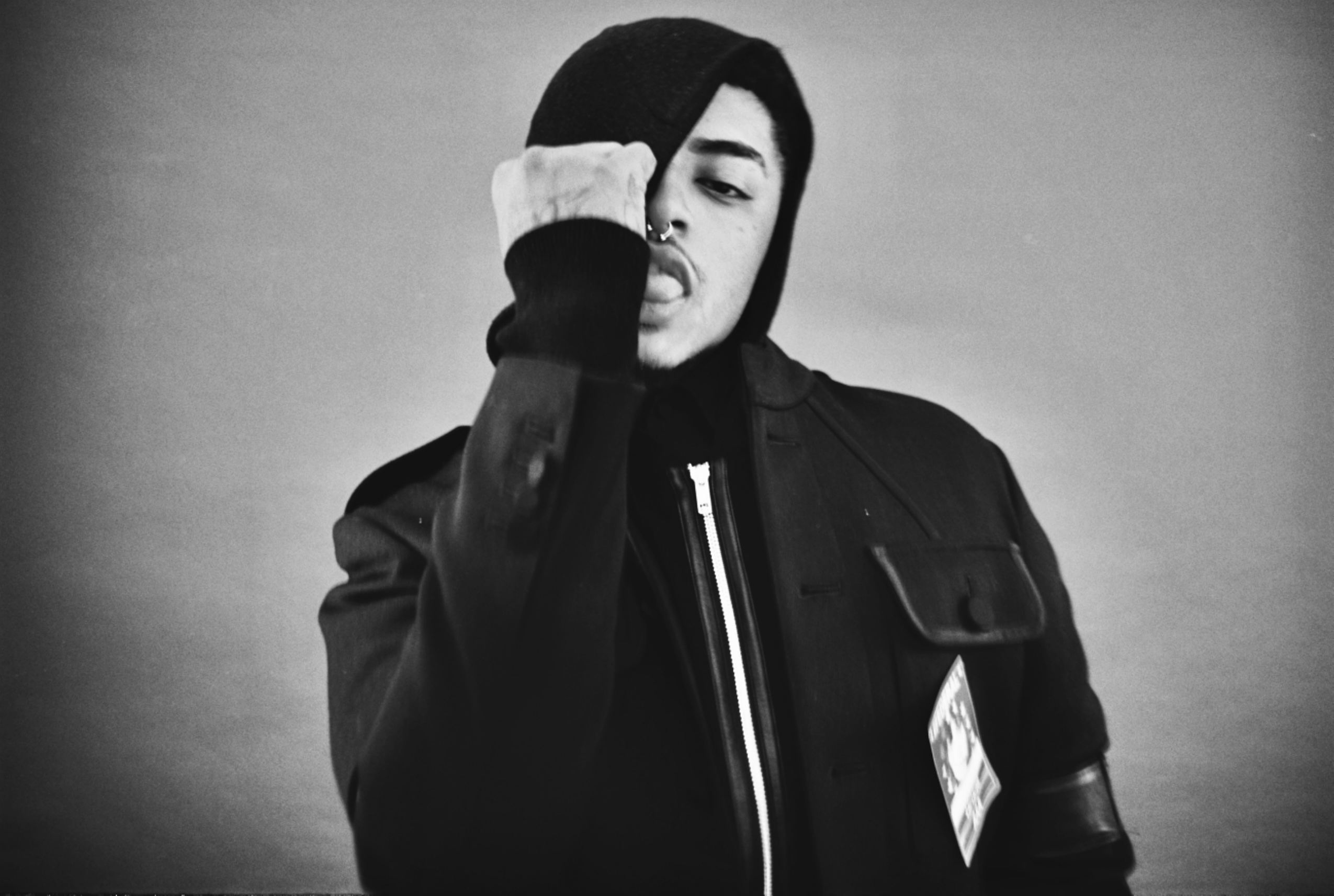 SINN6R assis dans un studio sombre